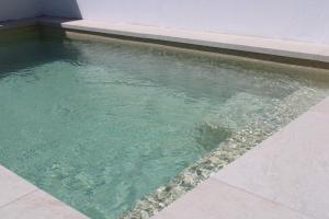 a pool of water next to a building at Azinheira Villa - Grândola in Azinheira dos Barros