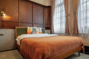 基隆的住宿－安樓文旅Enzo House，一间卧室配有一张带大型木制床头板的床