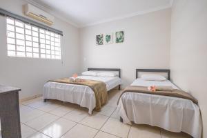 a bedroom with two beds and a window at Casa completa c/ Piscina - Excelente localização in Caldas Novas