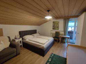 1 dormitorio con 1 cama grande y 1 sofá en Garni Hattlerhof B&B, en Brunico