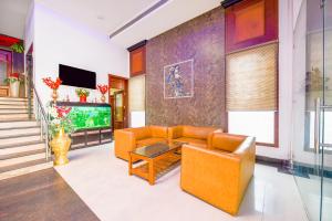 sala de estar con muebles de color naranja y TV en FabHotel Prime The Mirage en Ludhiana