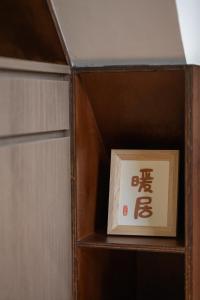 uma estante de livros de madeira com um cartaz em 安樓文旅Enzo House em Keelung