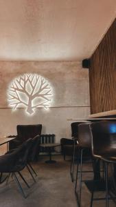 a room with tables and chairs and a sign on the wall at Amber Shore Apartment in Liepāja