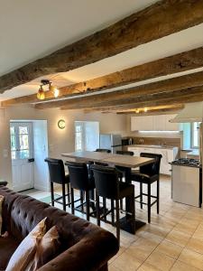 a kitchen with a couch and a table and chairs at Gîte Le Four à Pain 6 personnes sur le domaine du Manoir du Rigouneix in Saint-Angel