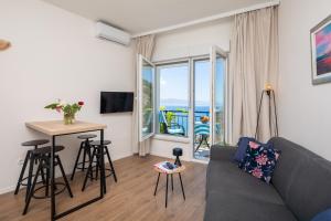 a living room with a couch and a table at Caleta Seaview Suites II - Pool & Jacuzzi in Lokva Rogoznica