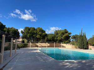 a swimming pool in a yard with trees in the background at Apt 4-6pers-piscine-parc arboré in Fitou