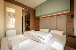 a bedroom with two beds with white sheets at M&V Resort Camping in Langrune-sur-Mer +37 photos