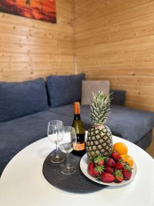 uma mesa com um prato de frutas e uma garrafa de vinho em Zielona Dolina Sarbinowo em Sarbinowo