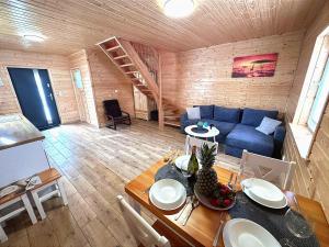 - un salon avec une table et un canapé bleu dans l'établissement Zielona Dolina Sarbinowo, à Sarbinowo