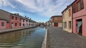 a canal in a city with buildings and a bridge at B&B Residenza Luciani Affittacamere in Comacchio