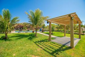 eine hölzerne Pergola in einem Park mit Palmen in der Unterkunft Refúgio de Lazer: Chácara c/ Espaço e Conforto in Caldas Novas