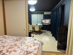a room with a bed and a desk and a television at Hamachidesu - Vacation STAY 15817 in Akiruno