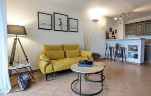 a living room with a yellow couch and a table at Nouvelle location dans somptueux golf avec piscine, terrains de tennis - situation ++ pour découvrir la Provence in Saumane-de-Vaucluse