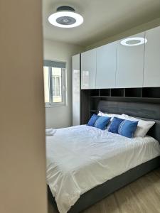 a bedroom with a large bed with blue pillows at The Rue in Il-Gżira