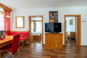 a living room with a television and a dining table at enJoy Appartements in Sankt Kanzian