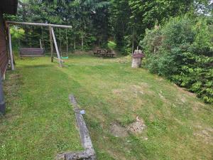 a backyard with a picnic table and a bench at Domek u Marysi in Bukowiec