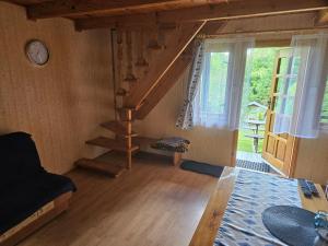 a living room with a staircase and a window at Domek u Marysi in Bukowiec