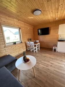 een woonkamer met een bank en een tafel bij Zielona Dolina Sarbinowo in Sarbinowo