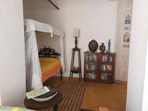 een slaapkamer met een hemelbed en een tafel bij Madakani House in Lamu