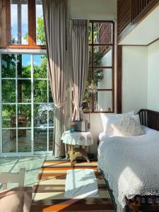 una camera con un letto e una grande finestra di Suksamer Relaxation Homestay 