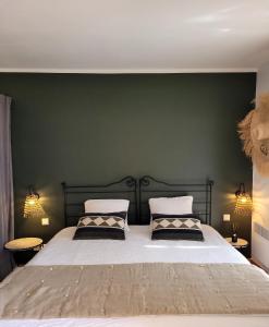a bedroom with a large bed with green walls at Nouvelle location dans somptueux golf avec piscine, terrains de tennis - situation ++ pour découvrir la Provence in Saumane-de-Vaucluse