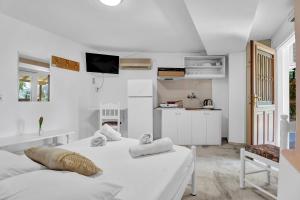 2 bedden in een witte kamer met een keuken bij Tasoula Studio with garden view in Nikiana