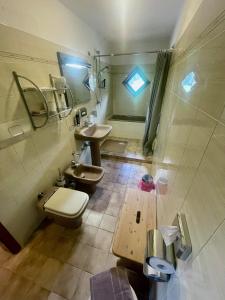 uma casa de banho com 2 lavatórios, um WC e uma janela em Hotel Biancaneve em Cogolo