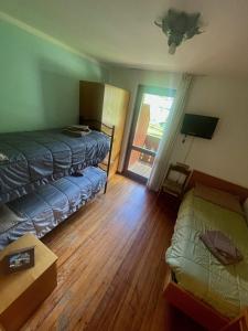 um pequeno quarto com 2 camas e uma janela em Hotel Biancaneve em Cogolo