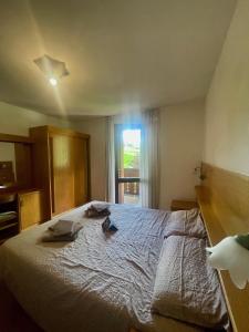 um quarto com uma cama com duas toalhas em Hotel Biancaneve em Cogolo
