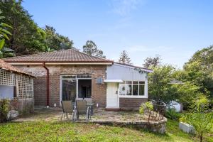 KillaraSpacious King Room - Nearby Stations & Stores - Shared Bathroom的庭院里带椅子的小砖屋