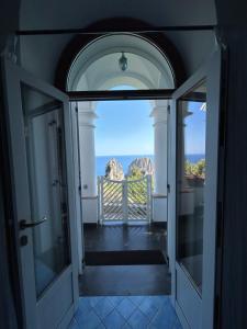 an open door to a balcony with a view of the ocean at Monacone vista mare in Capri