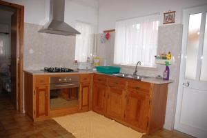 a kitchen with wooden cabinets and a sink and a stove at Casa Baptista I in Marinha Grande +5 photos