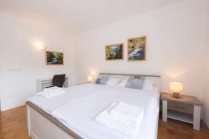 a bedroom with a large white bed and a desk at Apartment Panorama & Bella Vista in Bohinjska Bela