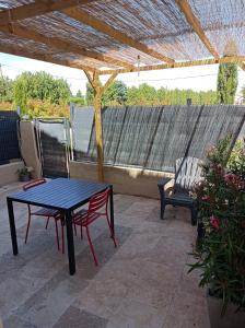 una mesa negra y un banco en un patio en Partie de mas en campagne, en Cavaillon