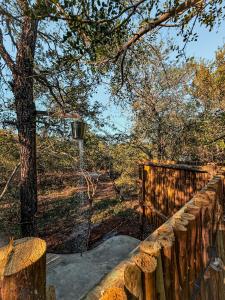 una valla de madera con un árbol en el fondo en Shongololo Bush Villa, en Marloth Park
