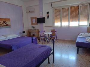 Una habitación con dos camas y una mesa y un televisor. en BBX Palermo Centro, en Palermo 7 fotos más