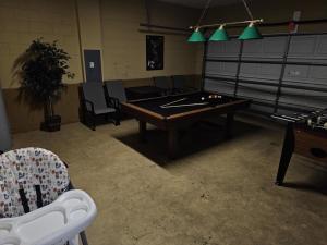 a room with a ping pong table and chairs at Spacious 7 BR, 4,5 BR Retreat with Pool 164 condo in Kissimmee