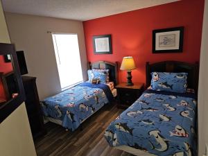 a bedroom with two beds and red walls at Spacious 7 BR, 4,5 BR Retreat with Pool 164 condo in Kissimmee +18 photos