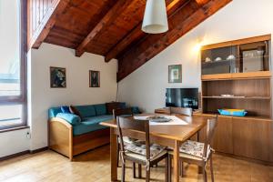 a living room with a table and a couch at Residenza Panarotta - Vetriolo(1500m) in Levico Terme