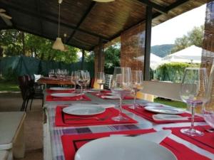 un tavolo con piatti rossi e bianchi e bicchieri da vino di Hostel Backpacker SOLOPUENT 3000 a Castiello de Jaca