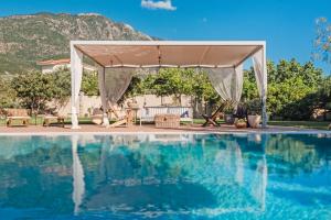 a wedding ceremony under a tent next to a swimming pool at Anamnesis. Feel the Mediterranean. in Kalamata