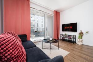 salon z kanapą i telewizorem w obiekcie Lumina cozy apartments Manufaktura w Łodzi