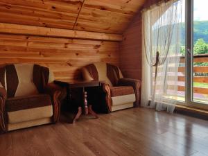 2 Stühle und ein Tisch in einem Zimmer mit Fenster in der Unterkunft "У Яслигана" in Pilipets