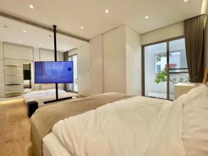 1 dormitorio con 1 cama grande y TV en 里白民宿 en Ho-mu