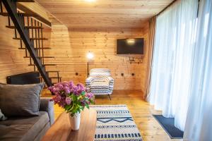 a living room with a couch and a table with flowers at Sunset Cottage Kazbegi in Kazbegi