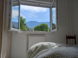 a bedroom with a window with a bed and a view at Aix-les-bains centre, 2 ch, 4 pers, climatisé in Aix-les-Bains