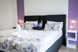 a large bed with white sheets and pillows at Apartmaji Živa in Gornja Radgona