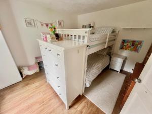 ein Kinderschlafzimmer mit einem Etagenbett und einer Kommode in der Unterkunft Large Country Farmhouse with Garden and Stream in Doagh