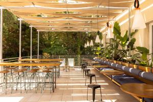 an outdoor patio with tables and chairs and plants at Ostello della Gioventù Brindisi in Brindisi
