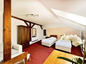 a attic room with two beds and a table at Hotel Růžek in Hranice